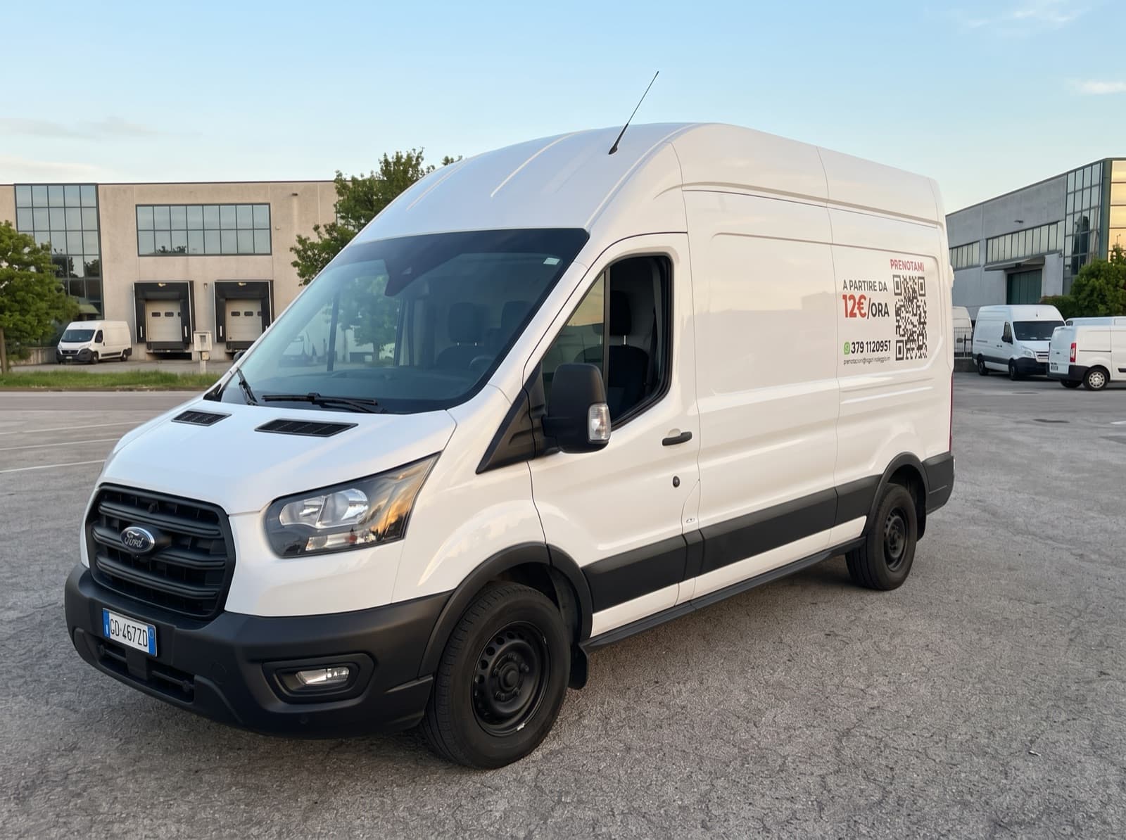 Ford Transit bianco a tetto alto visto di tre quarti, con la grafica RG SRL e il QR code per prenotare